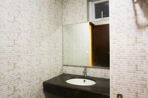 a bathroom with a sink and a mirror at Philomena Hotel & Apartment in Thanjāvūr