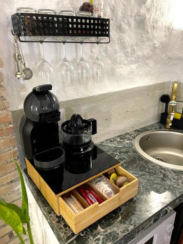 a coffee maker on a counter with wine glasses at CUEVA DE DAVID in Granada
