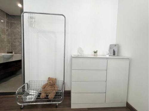a teddy bear sitting in a shopping cart in a bathroom at 80m2, 3BR apt - cozy & peaceful - City Center in Hai Phong