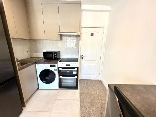 a kitchen with a dishwasher and a washer at Spectacular Modern, Private Apartment,15 Mins To Central London in Hendon