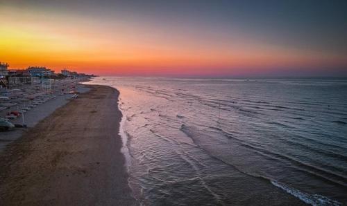 a view of a beach at sunset with the ocean at Relais Verde Casa in Trecastelli