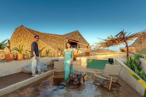 a man and a woman standing next to a pool at Hotel Villas Flamingos in Holbox Island