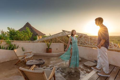 a man and a woman standing on a roof at Hotel Villas Flamingos in Holbox Island