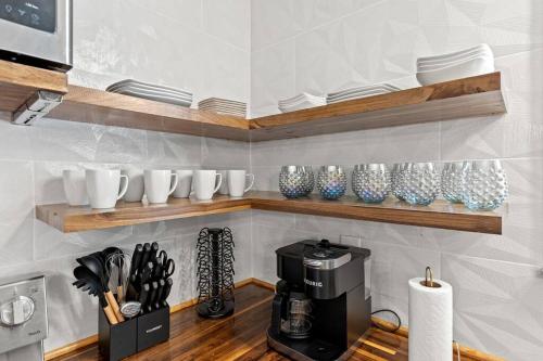a kitchen with shelves with cups and a coffee maker at The Luxe Hot Tub Private Bar 12 Min to Horse Park in Georgetown