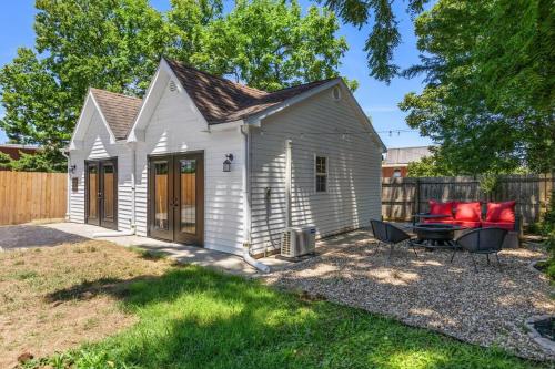 a small white shed with a table and chairs in a yard at The Luxe Hot Tub Private Bar 12 Min to Horse Park in Georgetown