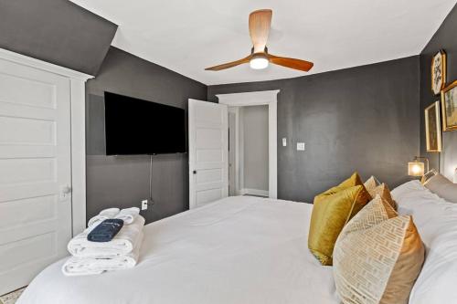 a bedroom with a white bed with a ceiling fan at The Luxe Hot Tub Private Bar 12 Min to Horse Park in Georgetown
