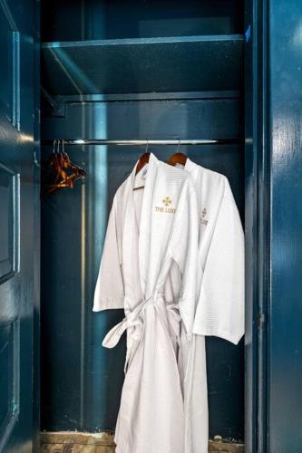 a white robe is hanging in a blue room at The Luxe Hot Tub Private Bar 12 Min to Horse Park in Georgetown