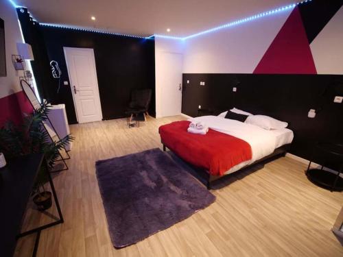 una camera da letto con un letto grande con una coperta rossa di Red Room - Olympe Suites & Spa Lille, Croix, Roubaix a Croix