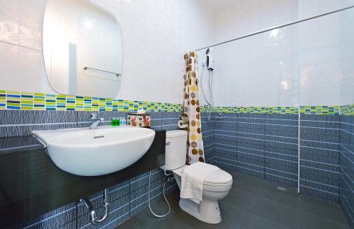 a bathroom with a sink and a toilet and a mirror at Kiss Hometel in Ao Nang Beach