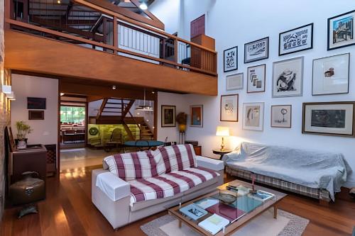 セクレタリオにあるCasa Secretário - 3 Suítes, Piscina, Campo e Saunaのソファと階段のあるリビングルーム