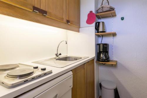 une petite cuisine avec un évier et une cuisinière dans l'établissement Résidence La Porte De Montchavin - En plein coeur de Montchavin studio coquet MAE-9224, à Aime La Plagne