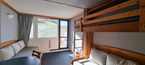 Cette petite chambre comprend des lits superposés et une fenêtre. dans l'établissement Résidence Etoile - Studio pour 4 Personnes 374, à Aime La Plagne