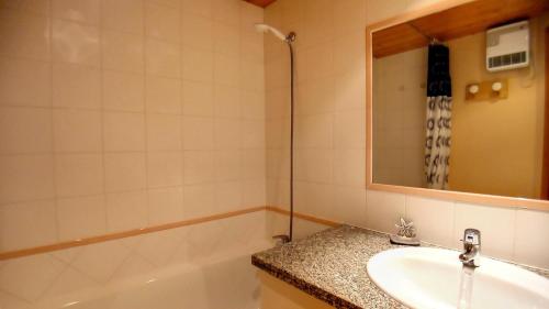 une salle de bain avec un lavabo, une baignoire et un miroir dans l'établissement Résidence Etoile - Studio pour 4 Personnes 374, à Aime La Plagne