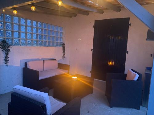 een kamer met witte meubels en vloerlampen bij Maison Vert d'Eau in Grand-Village-Plage