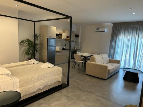a bedroom with a bed and a chair and a table at X luxury suites in Argostoli