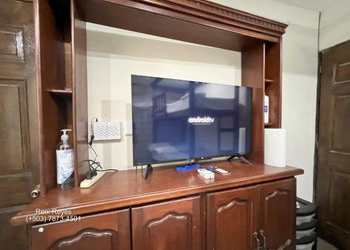 a flat screen tv sitting on top of a wooden entertainment center at Las Veraneras Villa - Pet Friendly in Acajutla