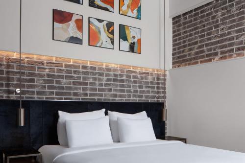 a bedroom with a brick wall and a bed with white pillows at DeCamondo Galata, a Tribute Portfolio Hotel in Istanbul