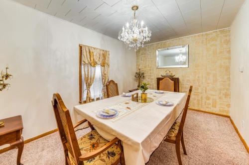 a dining room with a table and chairs and a chandelier at Ottawa Home with Porch, Near Starved Rock State Park in Ottawa