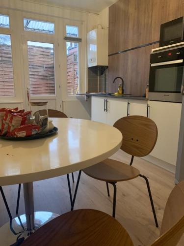 une cuisine avec une table et des chaises dans une pièce dans l'établissement Jolie Maison de ville, à Valenciennes