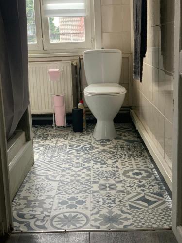 La salle de bains est pourvue de toilettes et de carrelage. dans l'établissement Jolie Maison de ville, à Valenciennes
