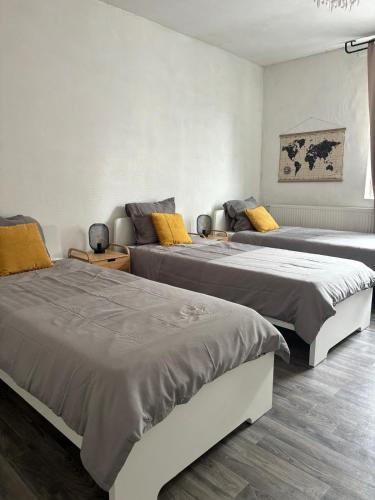 Cette chambre comprend trois lits et un canapé. dans l'établissement Jolie Maison de ville, à Valenciennes