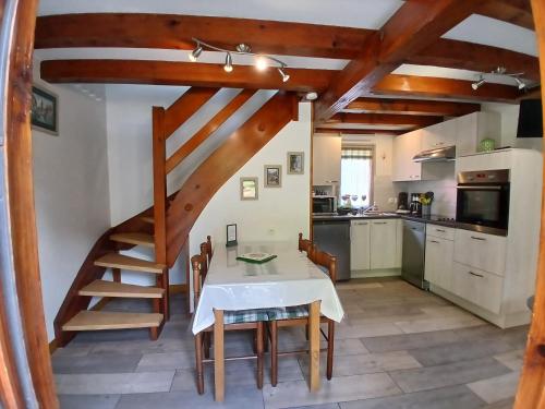 une cuisine et une salle à manger avec une table et un escalier dans l'établissement Gite Pinot Gris et gite Pinot Blanc, à Kaysersberg