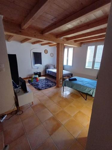 un salon avec un lit et une télévision dans l'établissement maison de village, à Montferrat