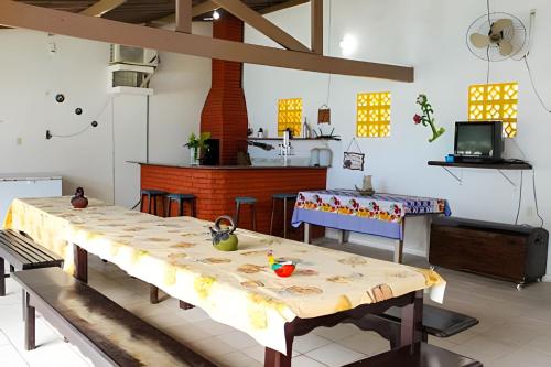 un salon avec une table et une cuisine dans l'établissement Casa na ilha da Crôa, à Barra de Santo Antônio
