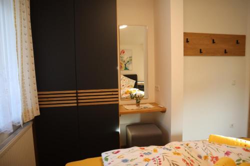 a bedroom with a bed and a desk and a mirror at Landhaus-Appartements Warraich in Schladming
