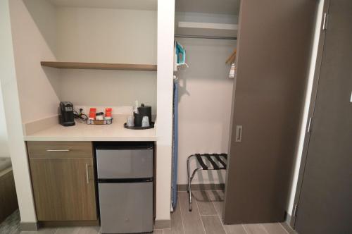 a small kitchen with a counter and a refrigerator at Best Western Plus Executive Residency Austin - Round Rock in Austin