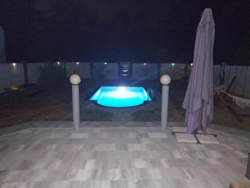 a swimming pool at night with an umbrella at Sarajevo Villa Sunce in Ilijaš