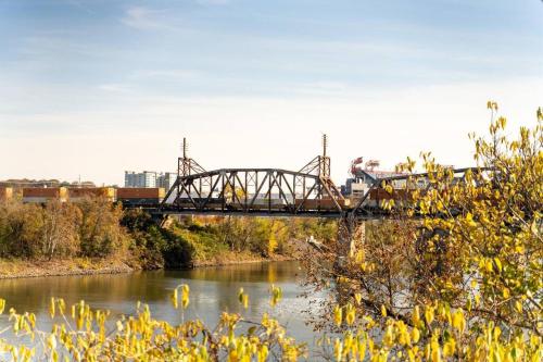 a train crossing a bridge over a river at Amazing pool, Steps 2 Broadway right on the Riverfront! in Nashville