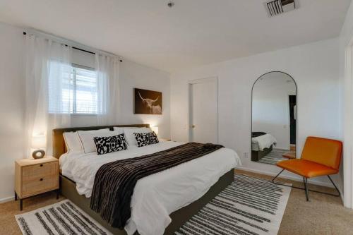 a bedroom with a bed and a chair and a mirror at Amazing pool, Steps 2 Broadway right on the Riverfront! in Nashville