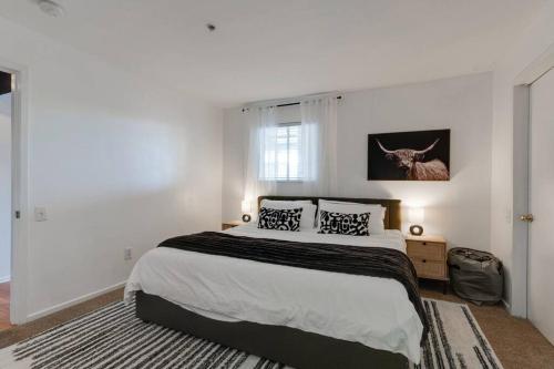 a white bedroom with a large bed with two pillows at Amazing pool, Steps 2 Broadway right on the Riverfront! in Nashville
