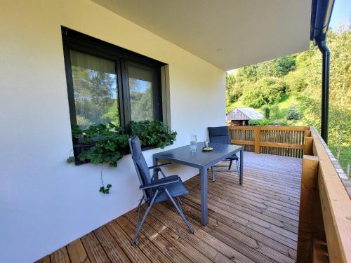a patio with a table and a chair on a deck at Apartmán v tichu in Teplice nad Metují