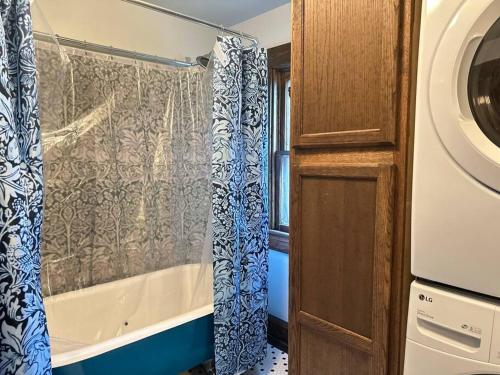 a bathroom with a tub and a shower curtain at 1867 Gothic VanDeventer Home in Saint Joseph