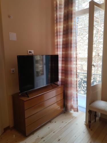 a flat screen tv sitting on a dresser in front of a window at 1920 Classic in Kalamata