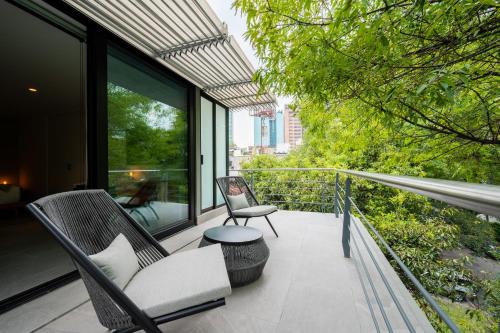 a balcony with two chairs and a table at Capitalia Parque Lincoln in Mexico City