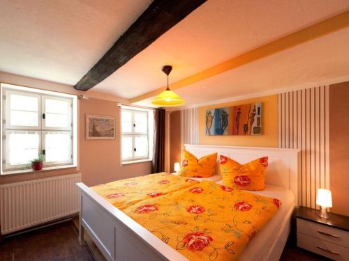 a bedroom with a large yellow bed with orange pillows at Holiday apartment sunshine in Quedlinburg