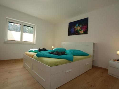 a bedroom with a bed with blue pillows on it at Ferienhaus am Rande der Lewitz in Lüblow