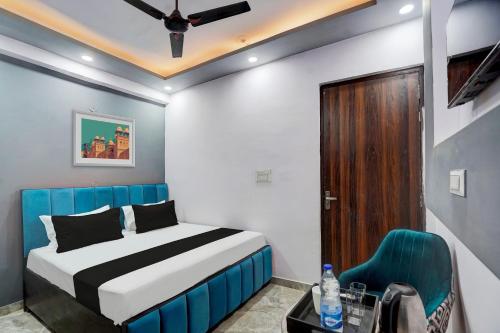 a bedroom with a bed and a blue chair at Hotel O The smart haven in Ghaziabad