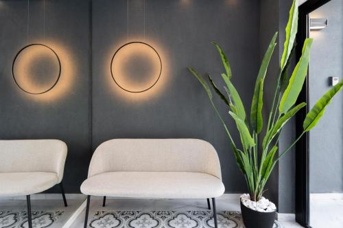 two chairs and a plant in a room at Kosmos Luxury Residences in Athens