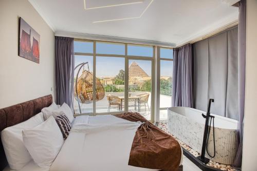 a hotel room with a bed and a view of the pyramids at Shadow Pyramids Suites and Jacuzzi in Cairo