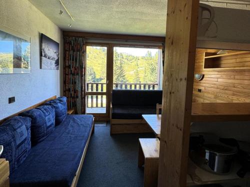 un salon avec un canapé bleu et un balcon dans l'établissement Résidence Turquoise - 2 Pièces pour 5 Personnes 69, à Mâcot La Plagne