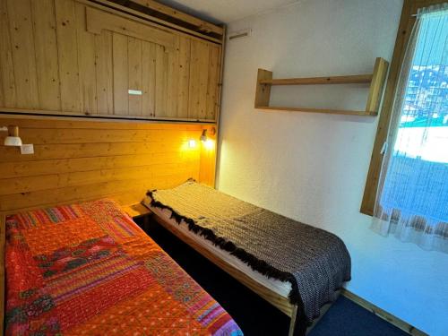 une chambre avec deux lits et une fenêtre dans l'établissement Résidence Turquoise - 2 Pièces pour 5 Personnes 69, à Mâcot La Plagne