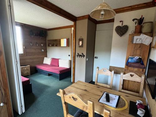 Cette petite chambre comprend une table et un lit. dans l'établissement Résidence Aigue-marine - Studio pour 4 Personnes 86, à Mâcot La Plagne