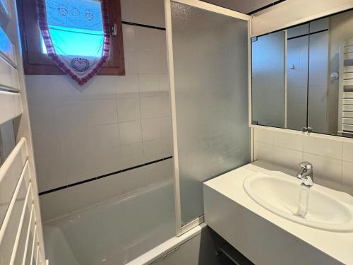 une salle de bain blanche avec un lavabo et une douche dans l'établissement Résidence Aigue-marine - Studio pour 4 Personnes 86, à Mâcot La Plagne
