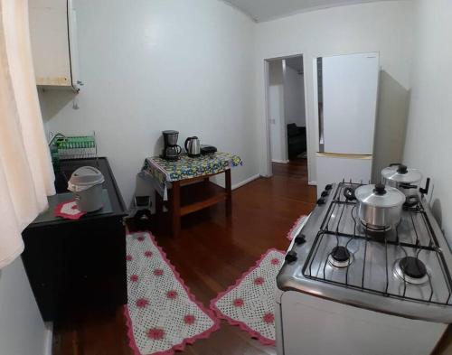 een keuken met een fornuis en een tafel bij Casa Com 2 quartos, Garagem Ar tv in Foz do Iguaçu