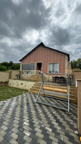 a brick house with a bench in front of it at Qubada gunluk dağ kiraye evi in Quba