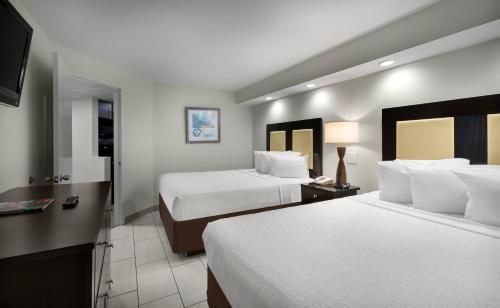 a hotel room with two beds and a desk at Captain's Quarters Resort in Myrtle Beach